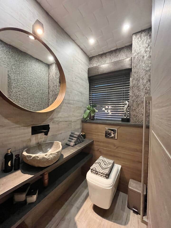 The modern W/C offers both style and convenience. Featuring a natural stone basin and sleek wood and stone accents, it's a functional space designed with contemporary elegance in mind - ideally situated on the living room  and kitchen floor.