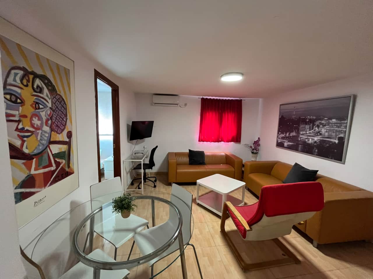 Living room with two sofas, dining table, desk, TV and air conditioning