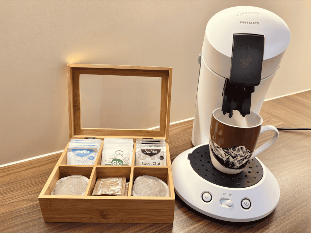 Senseo Kaffeemaschine mit einer Auswahl an Kaffeepads und Tee.