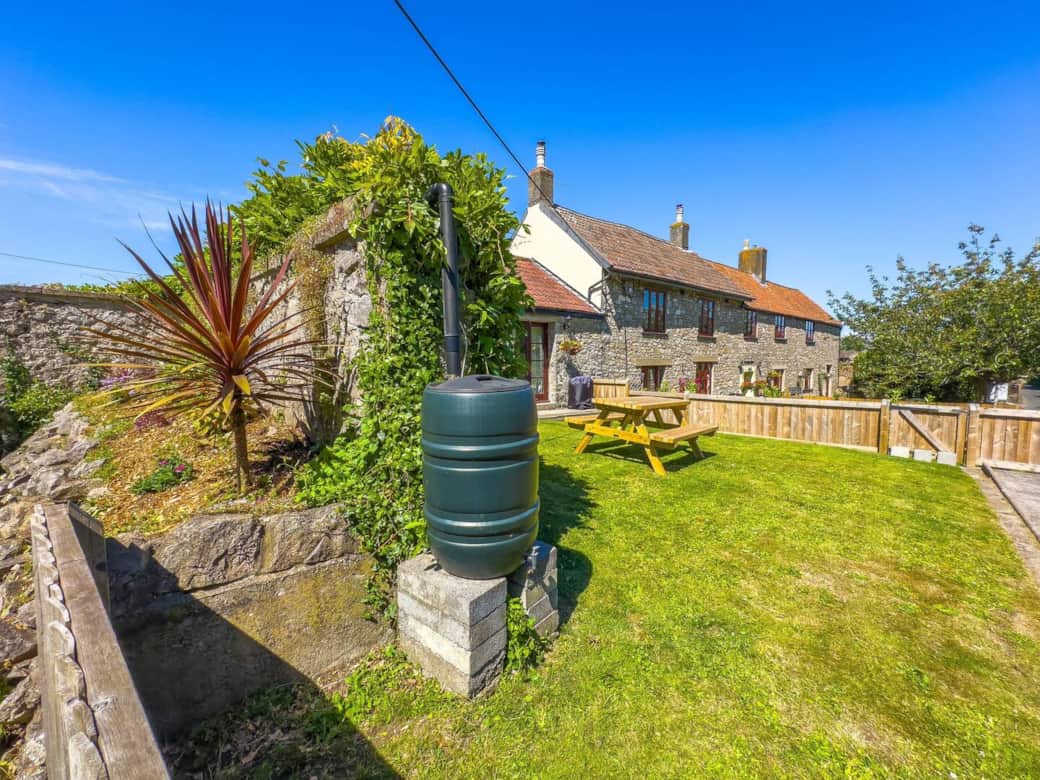 Farm Cottage enclosed garden with large picnic bench and patio doors from the living room