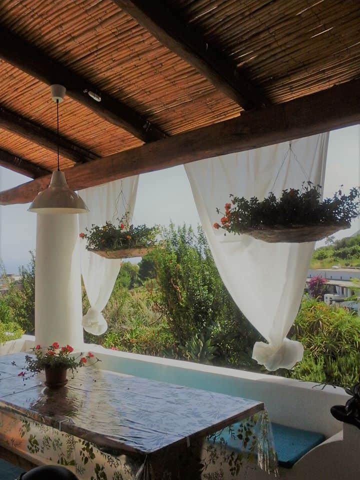 Veranda panoramica a Malfa, Salina, tra tende bianche e giardino mediterraneo. Relax nelle Eolie. Veranda panoramica a Malfa, Salina, tra tende bianche e giardino mediterraneo. Relax nelle Eolie.