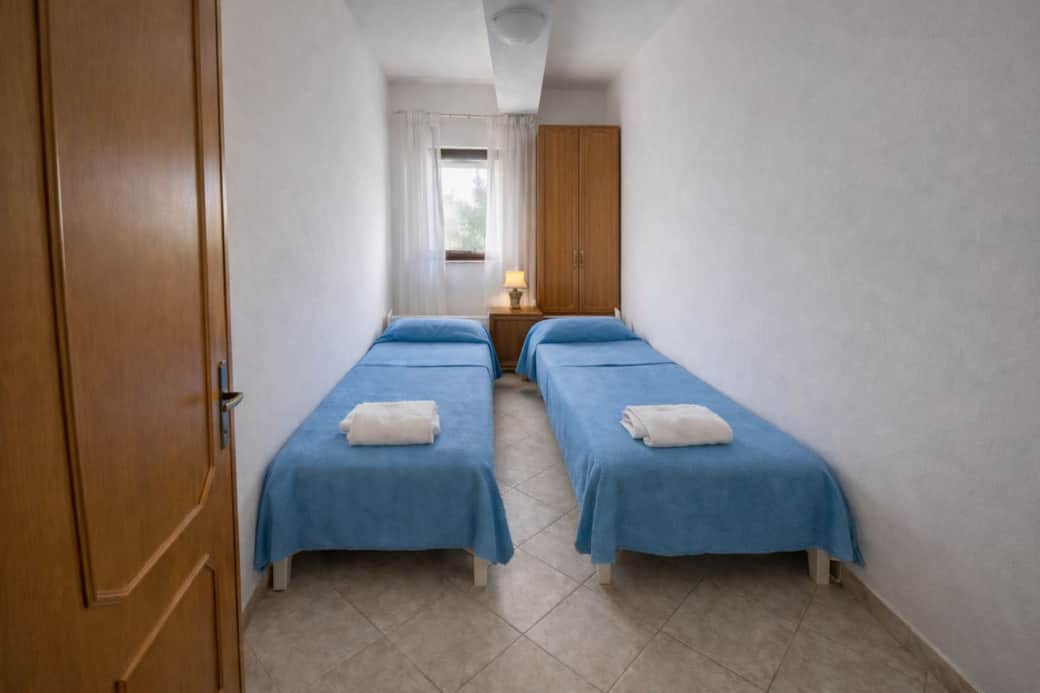 Camera accogliente con due letti singoli e disposizione funzionale, ideale per garantire comfort e privacy. Camera accogliente con due letti singoli e disposizione funzionale, ideale per garantire comfort e privacy.