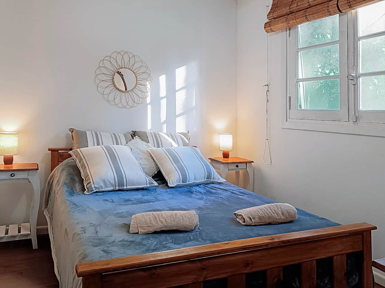 Dormitorio cama doble con sol de la mañana.