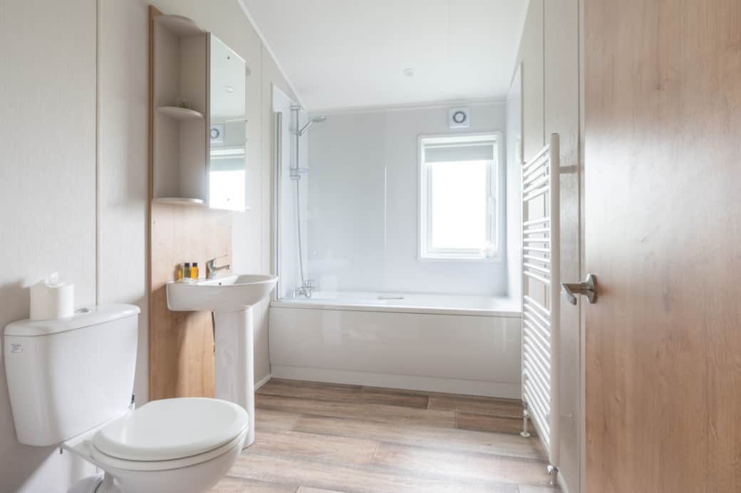 A bright family bathroom with bath and shower for relaxing after a day exploring