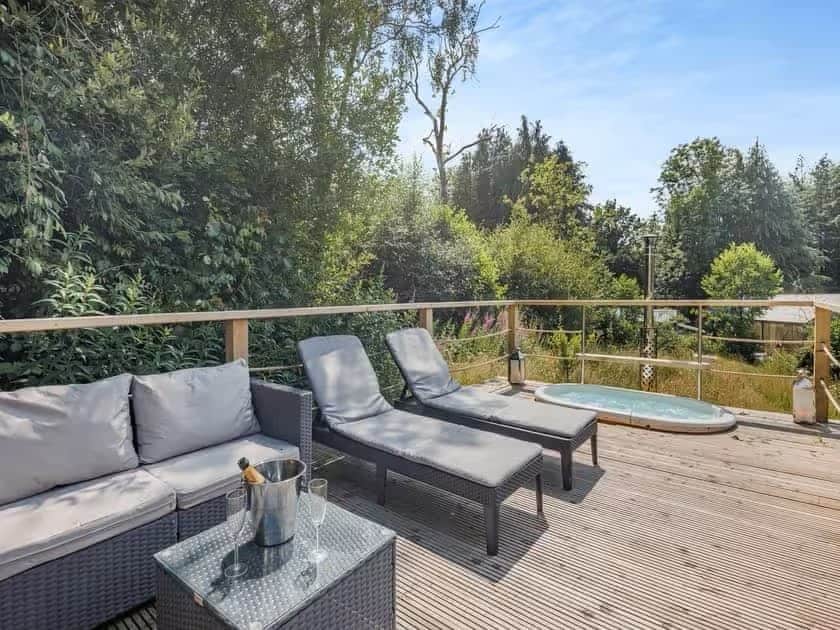 Private deck with seating, loungers and a wood-fired hot tub