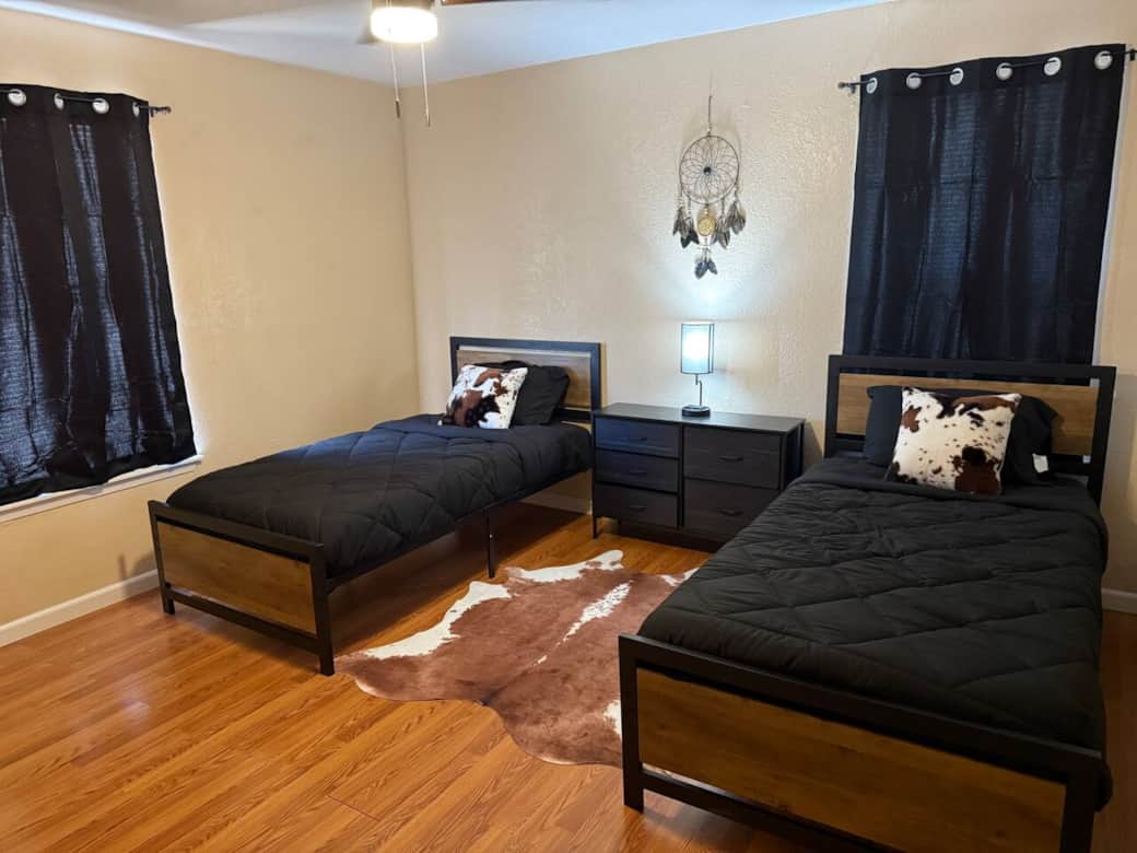 Comfortable twin beds in second bedroom with western decor and night lamp. Beautiful carpet to enhance the western look. 