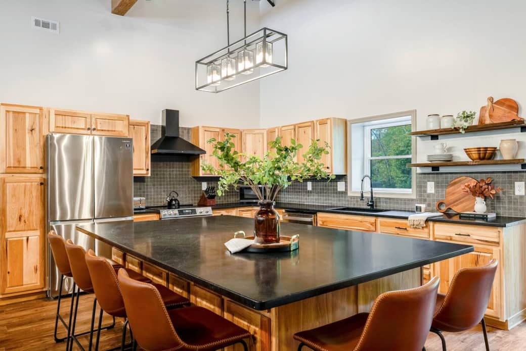 Large kitchen fully stocked with pots, pans, dishes, and utensils 