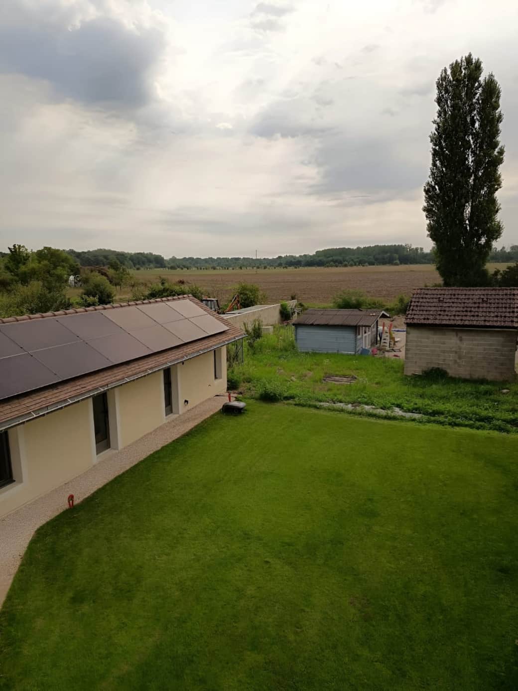Vue sur les champs, le sauna et la jardin.