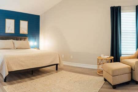 Primary bedroom with king size bed and reading area.