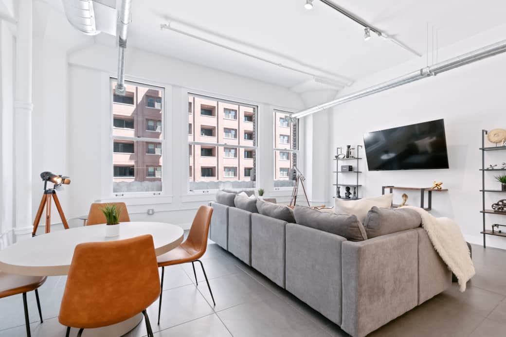 Spacious living and dining area with natural light, cozy seating, and a TV. Spacious living and dining area with natural light, cozy seating, and a TV.