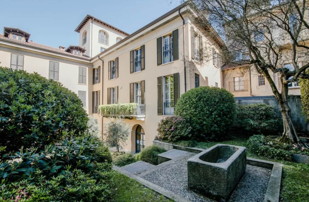 Cortile con vegetazione e fontana in pietra della palazzina