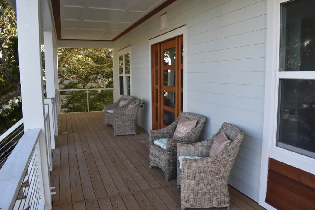 Inviting southern porch to relax in ocean breeze beneath the shade of coastal oak trees.