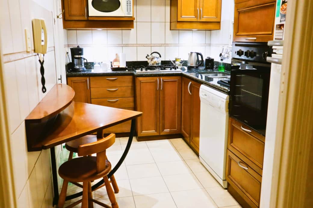 La cocina, totalmente equipada, te recibe con todo lo que necesitas. Cuenta con microondas, un práctico bar de café y té, y una mesa para dos con taburetes, perfecta para un desayuno relajado o una charla íntima.