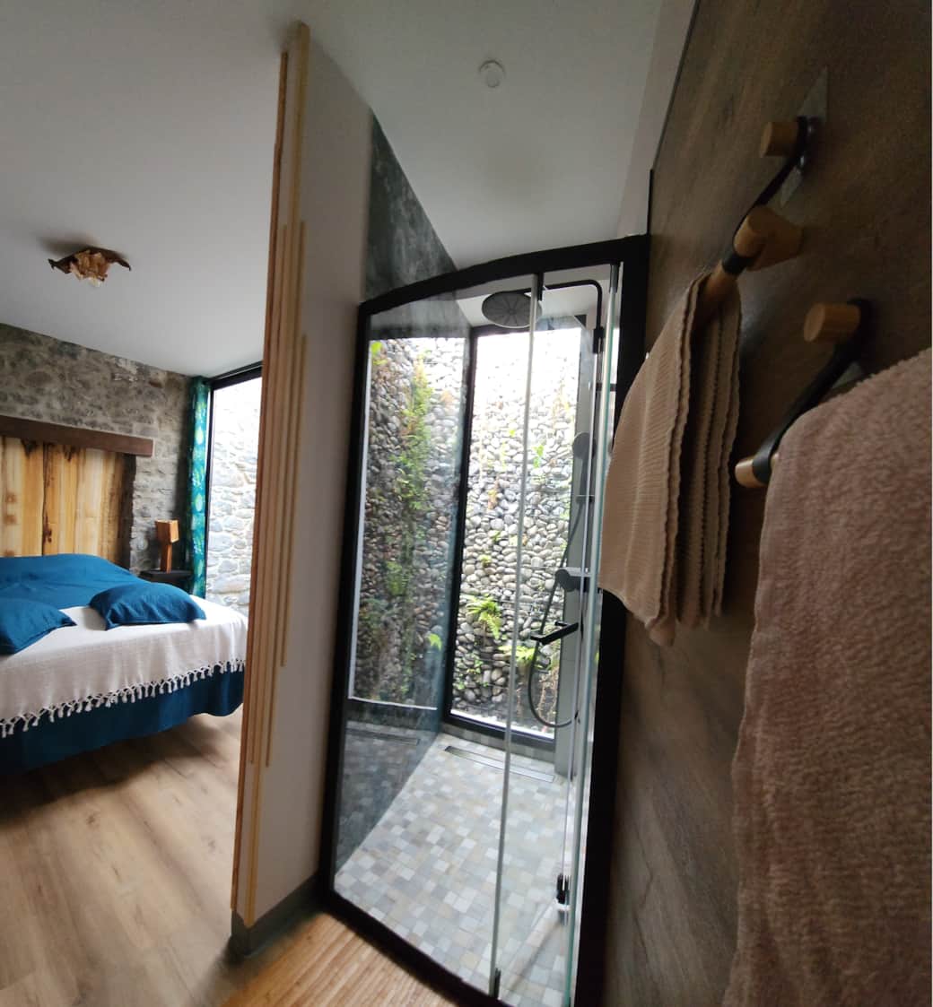 Floeca open-air shower with Tahiti-inspired indoor-outdoor flow, warm wood accents and lush tropical