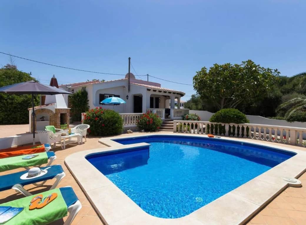Pool and patio with sun loungers and umbrella