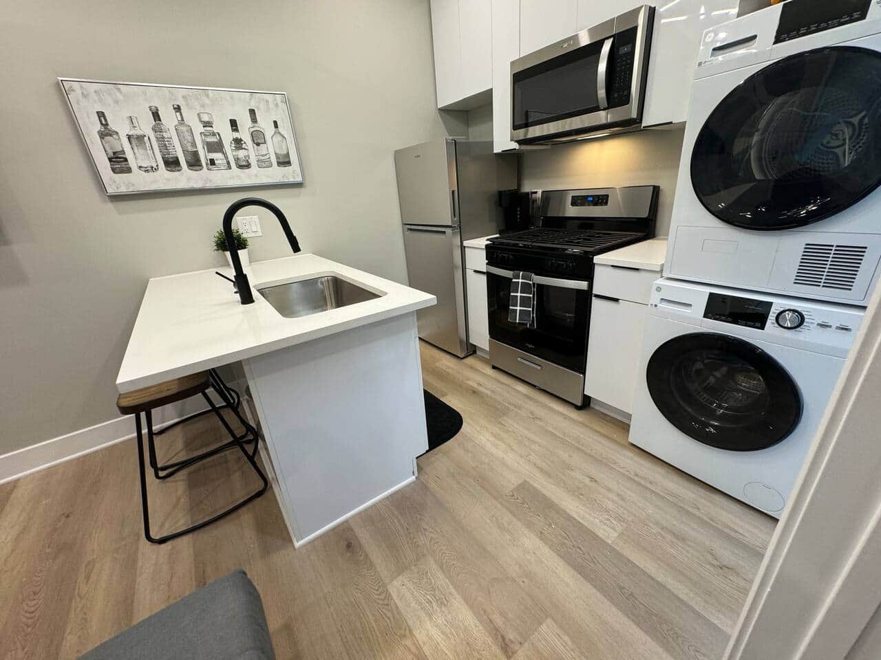 This beautiful kitchen, where you’ll find a quartz island with bar stools, perfect for enjoying meals or hanging out with friends. The kitchen is equipped with a refrigerator, microwave, and dishwasher, along with all the basic cooking essential.