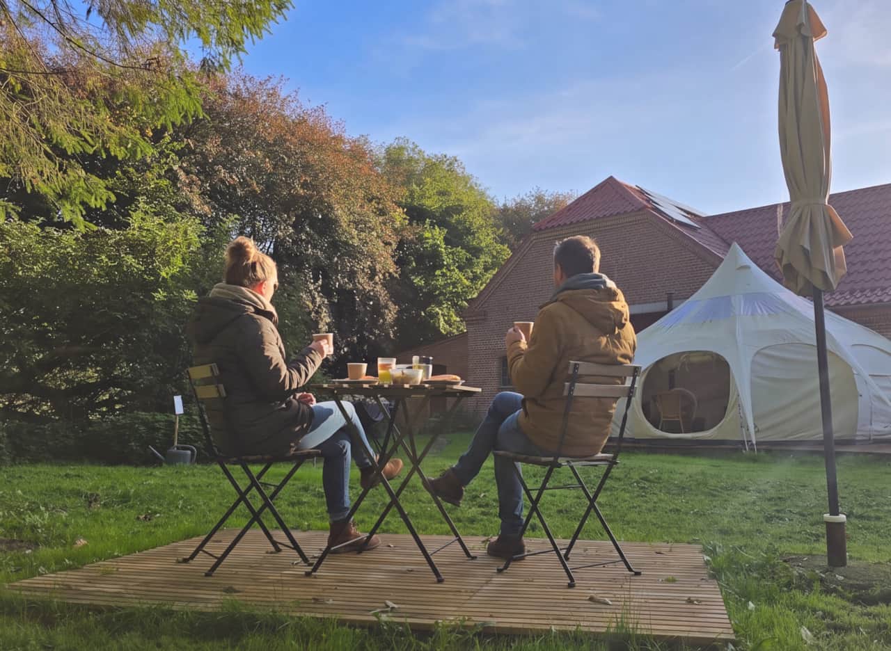 Breakfast for two in the garden with a view of the glamping tent on an autumn morning