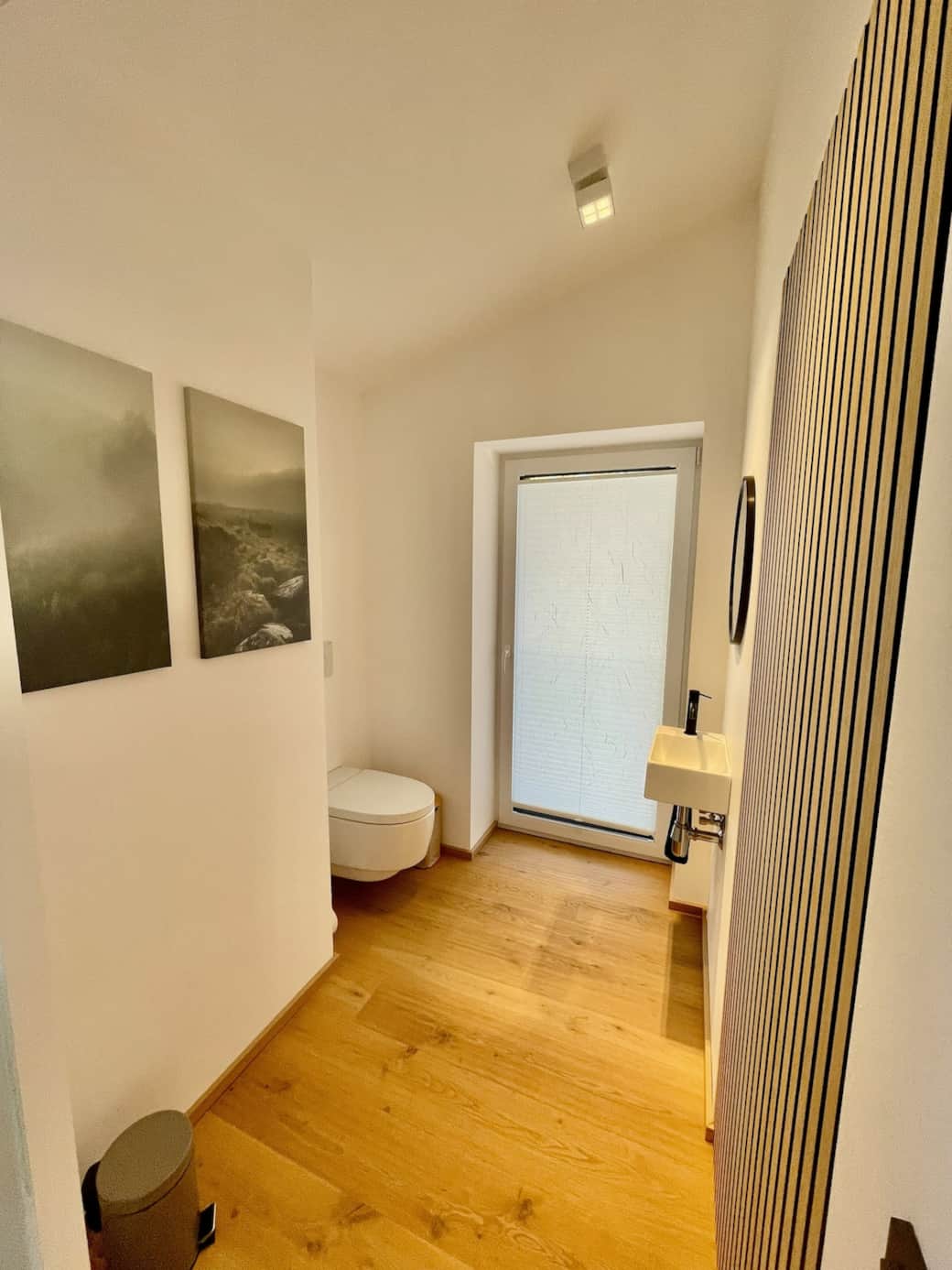 Das WC ist durch eine Schiebetür vom Badezimmer abgetrennt.