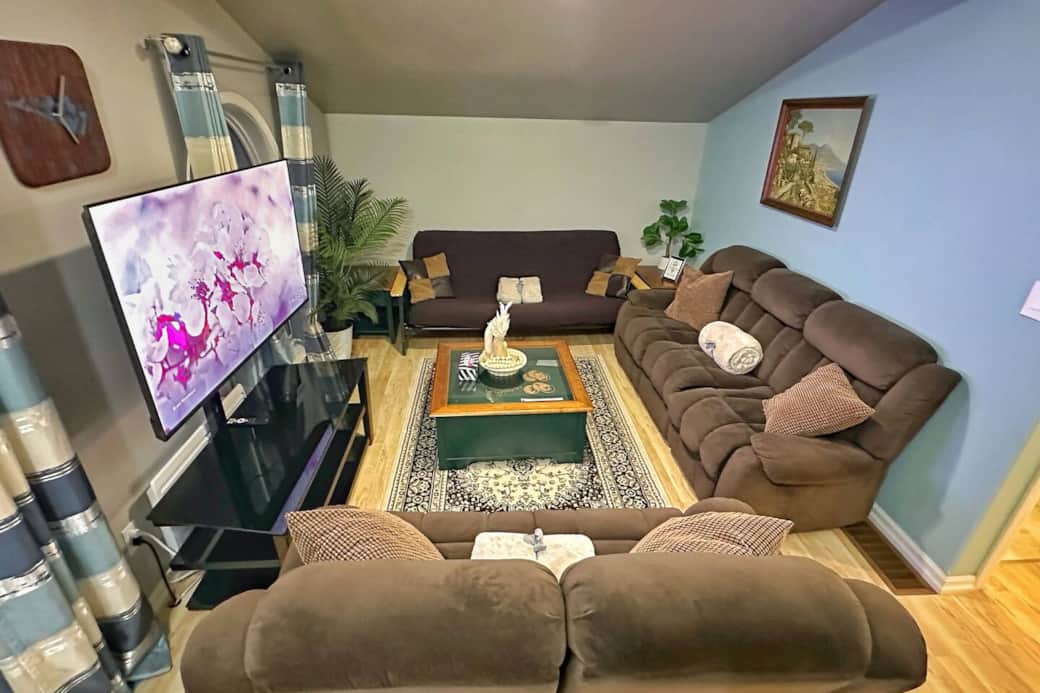 Bright and cozy living room with plush seating for the whole family, smart TV, and warm cottage décor.