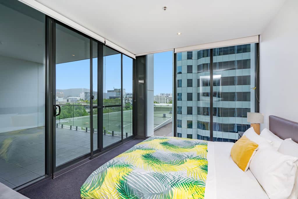 Wake up to brilliant views in our master bedroom. The large window offers a panoramic view of the city, while the vibrant bedspread adds a touch of energy to the room. Start your day on a high note with the sun streaming in and the city at your feet.