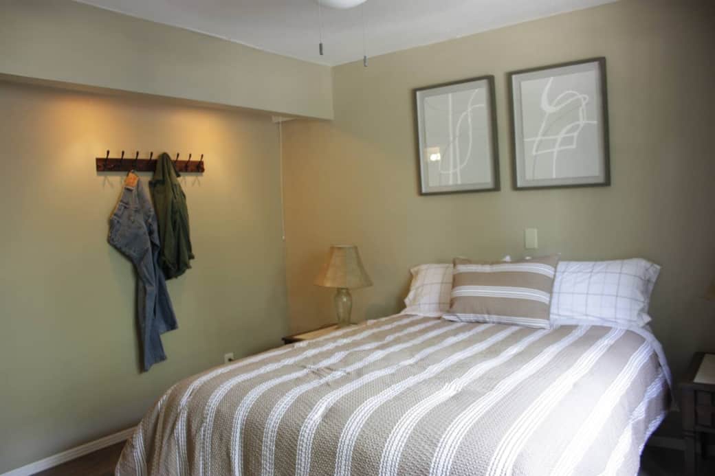 Master bedroom with queen bed an convenient hooks on the wall for your clothes