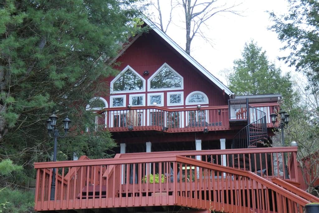 Lakefront chalet with multiple levels of decks leading to the water.