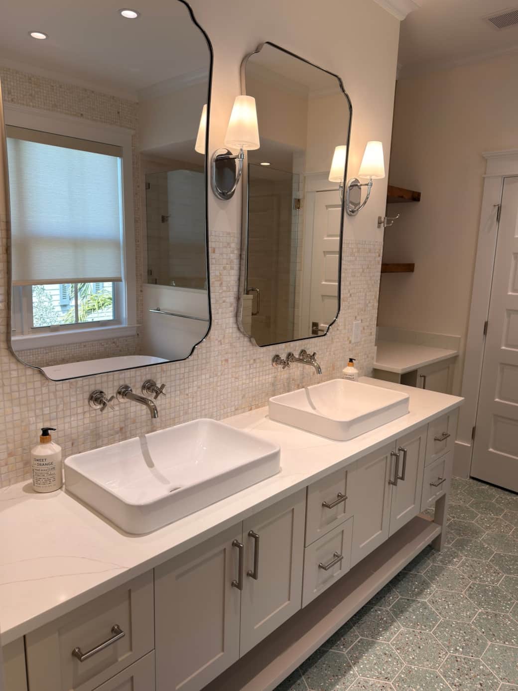 A spacious, spa-like en-suite bath featuring a walk-in shower, soaking tub, and his and hers vanity. Finished in a refined coastal-modern style, it offers a bright, luxurious setting designed for comfort, relaxation, and privacy.