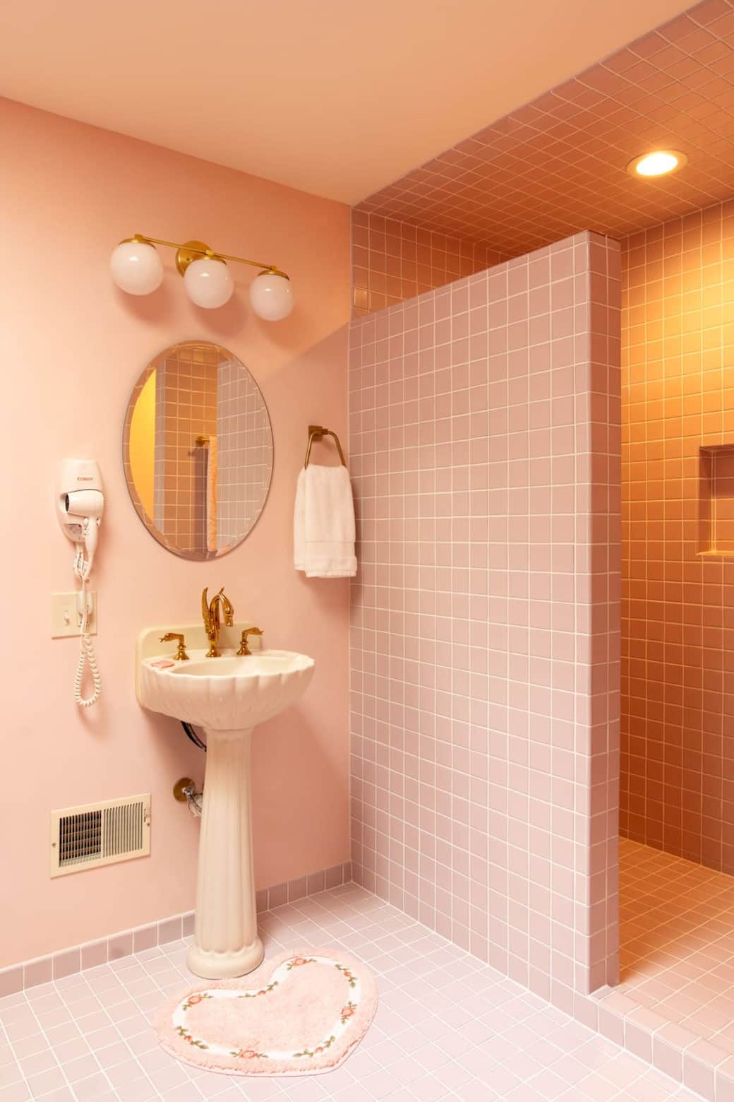 Pedestal sink with Swan faucet and pink shower tile Pedestal sink with Swan faucet and pink shower tile