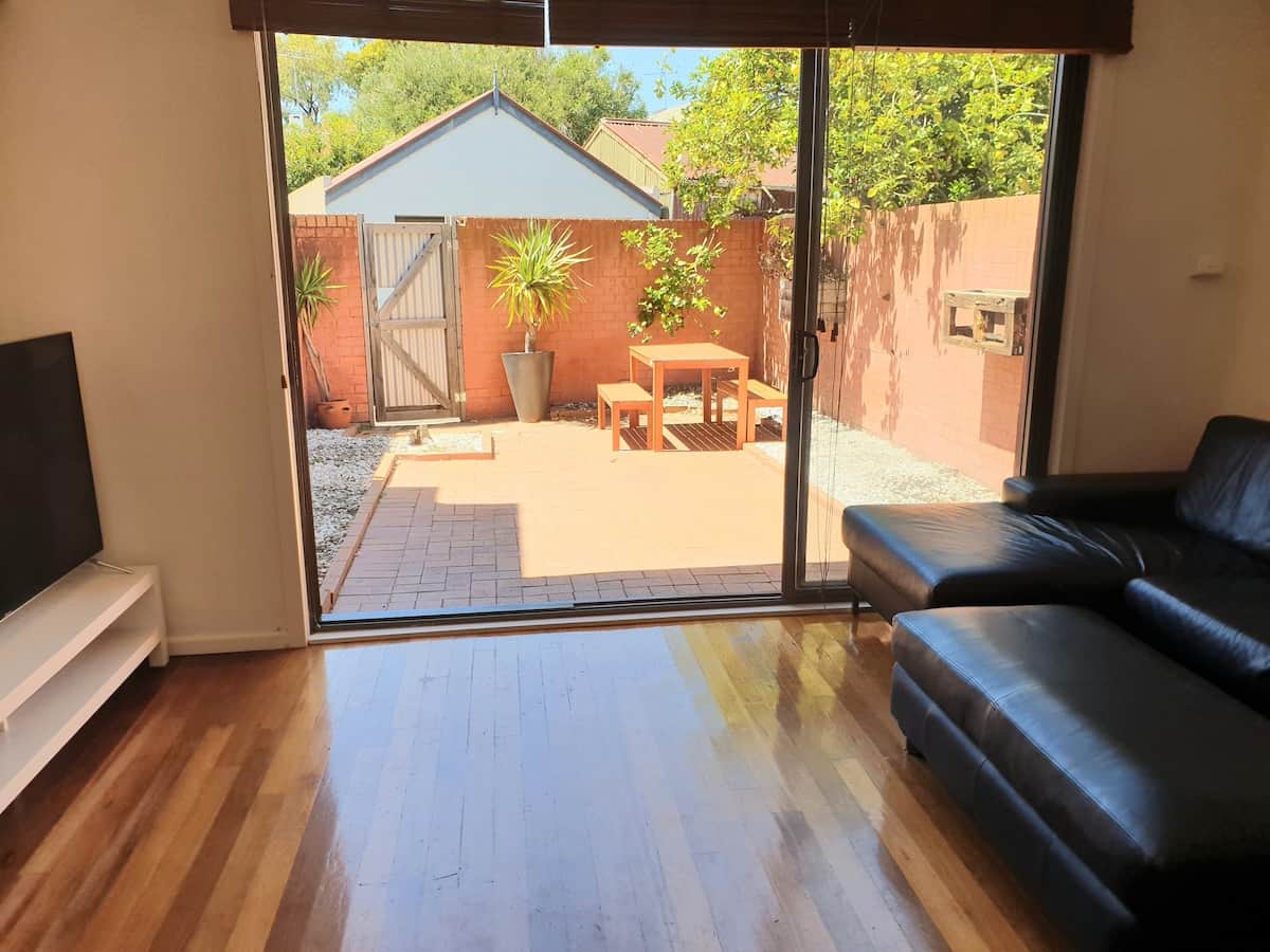 Three seater leather couch with chaise and ottoman overlooking the courtyard out of the large sliding doors.