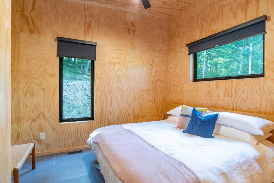 Escape to modern Scandinavian design in this king bed guest room. With plywood walls, a ceiling fan, overhead light, and room darkening shades, you'll sleep soundly. A bench and hooks offer convenient storage. Sleeps 2.