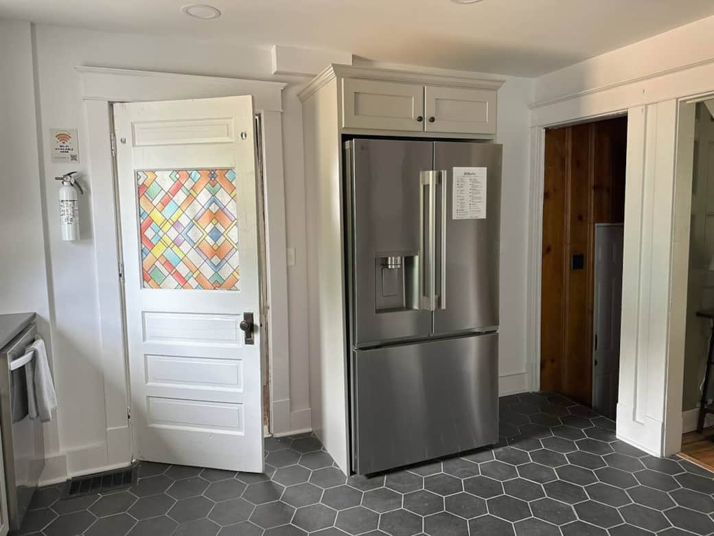Modern kitchen with induction stove, dishwasher, coffee bar & full cookware.