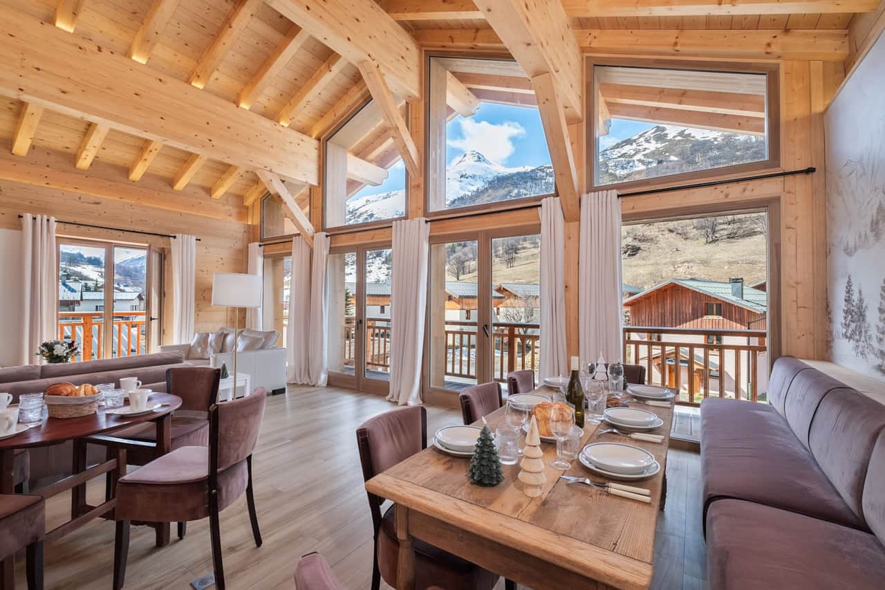 Bright living room with panoramic mountain views and magnificent cathedral bay windows.