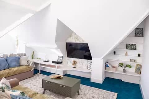 Bright, stylish loft living area with comfortable sofas, Smart TV, and coffee table Bright, stylish loft living area with comfortable sofas, Smart TV, and coffee table