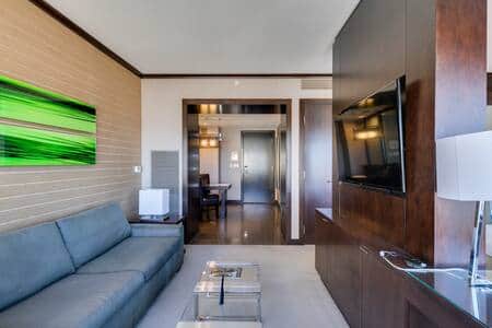 Open living room with sectional sofa and panoramic Strip-facing windows