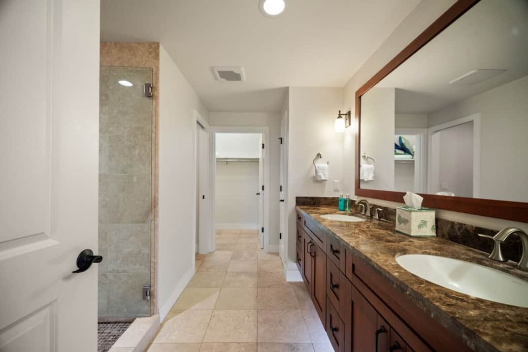 Master en-suite with stone tile, granite countertops, and walk-in closet