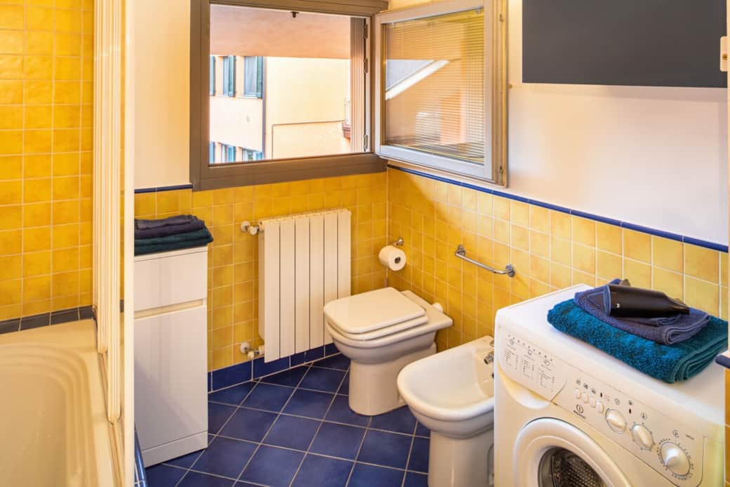 Tutte le comodità di casa: la zona bagno include una pratica lavatrice (ideale per soggiorni lunghi) e un asciugacapelli pronto all'uso.