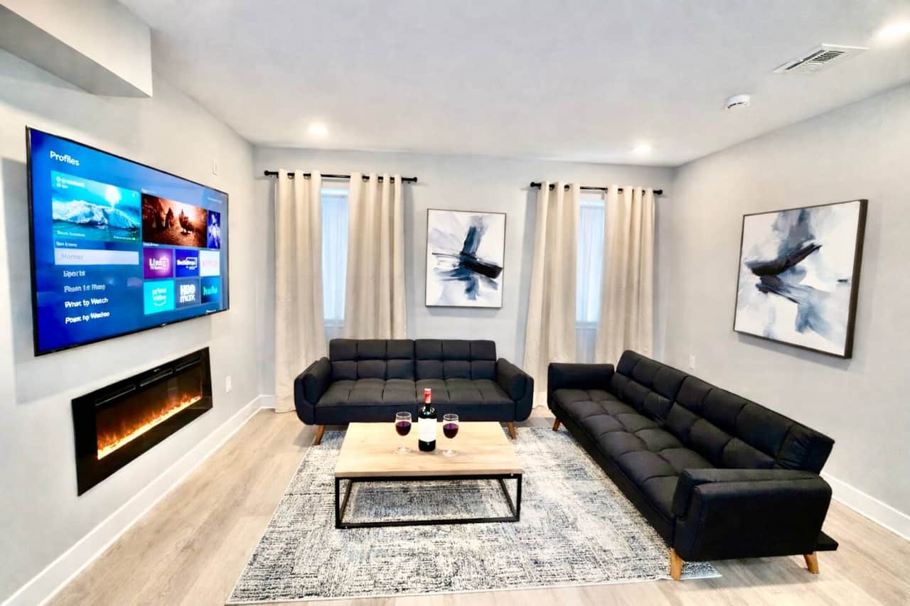 
Bright, modern living room with two comfortable sofa beds, a 60” flat-screen TV, and an electric fireplace. Perfect for relaxing, streaming, or accommodating extra guests.