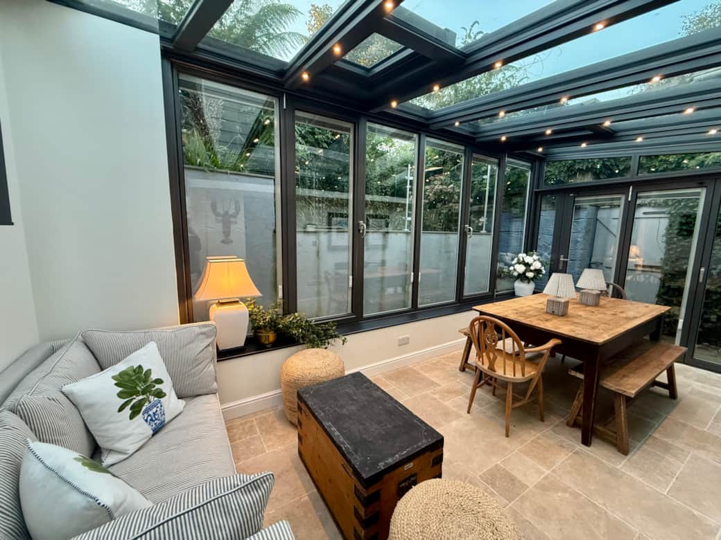 Spacious dining area with large rustic wooden table and vintage bifold doors