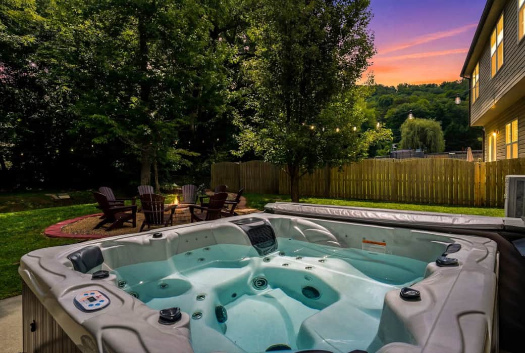 Lovely hot tube view at twilight with fire pit in background.. Lovely hot tube view at twilight with fire pit in background..