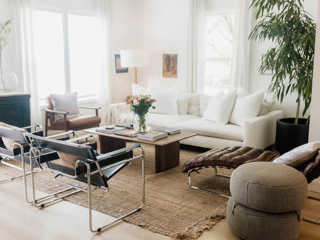 Light-filled and effortlessly refined, our living room layers soft linen seating, a sculptural leather, and warm wood tones for a relaxed, elevated feel. Styled with curated books and collected art, made for slow mornings and cozy nights 