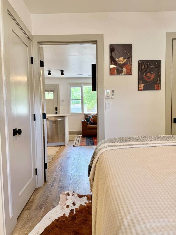 Peek-a-boo views from the bedroom give you a glimpse of that cozy couch and kitchen charm. With cowhide at your feet and starry cowboy art on the wall, even your walk to the coffee pot comes with a little Western flair.
