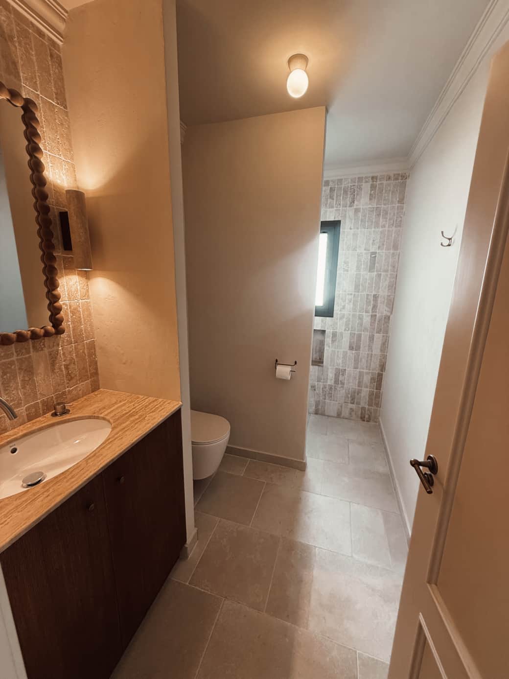 Ruime badkamer met inloopdouche, regendouche en föhn.