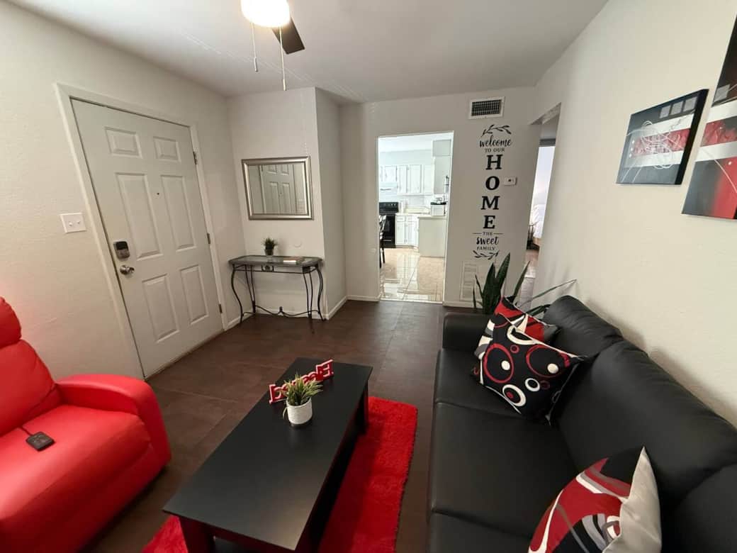 Modern living room with black leather couch and red massage chair 