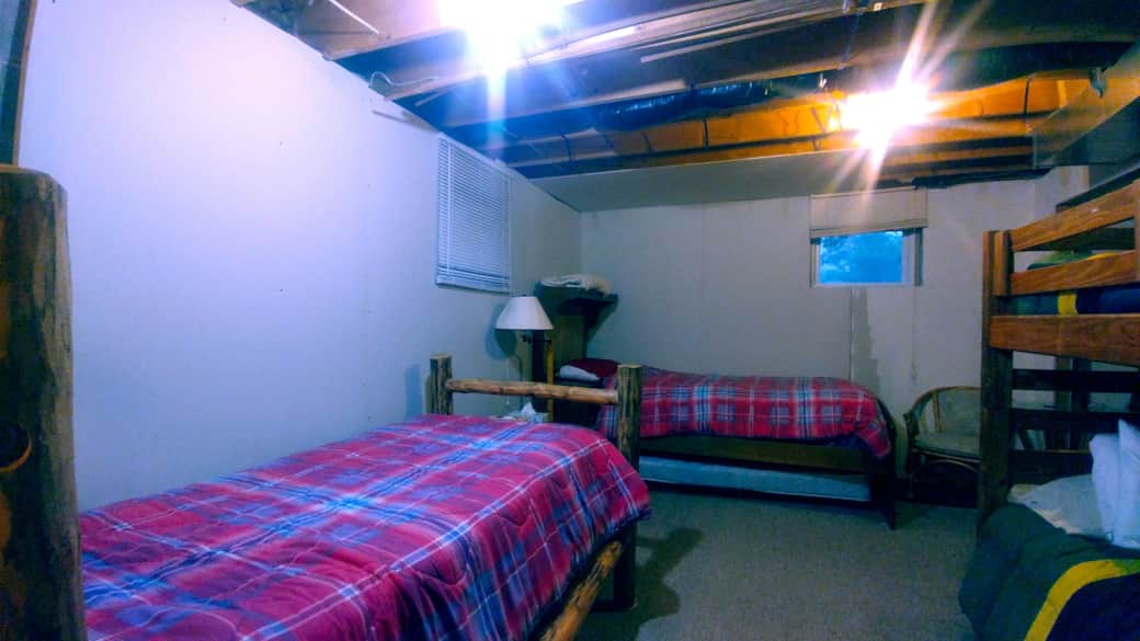 Basement back room with 4 unmade beds