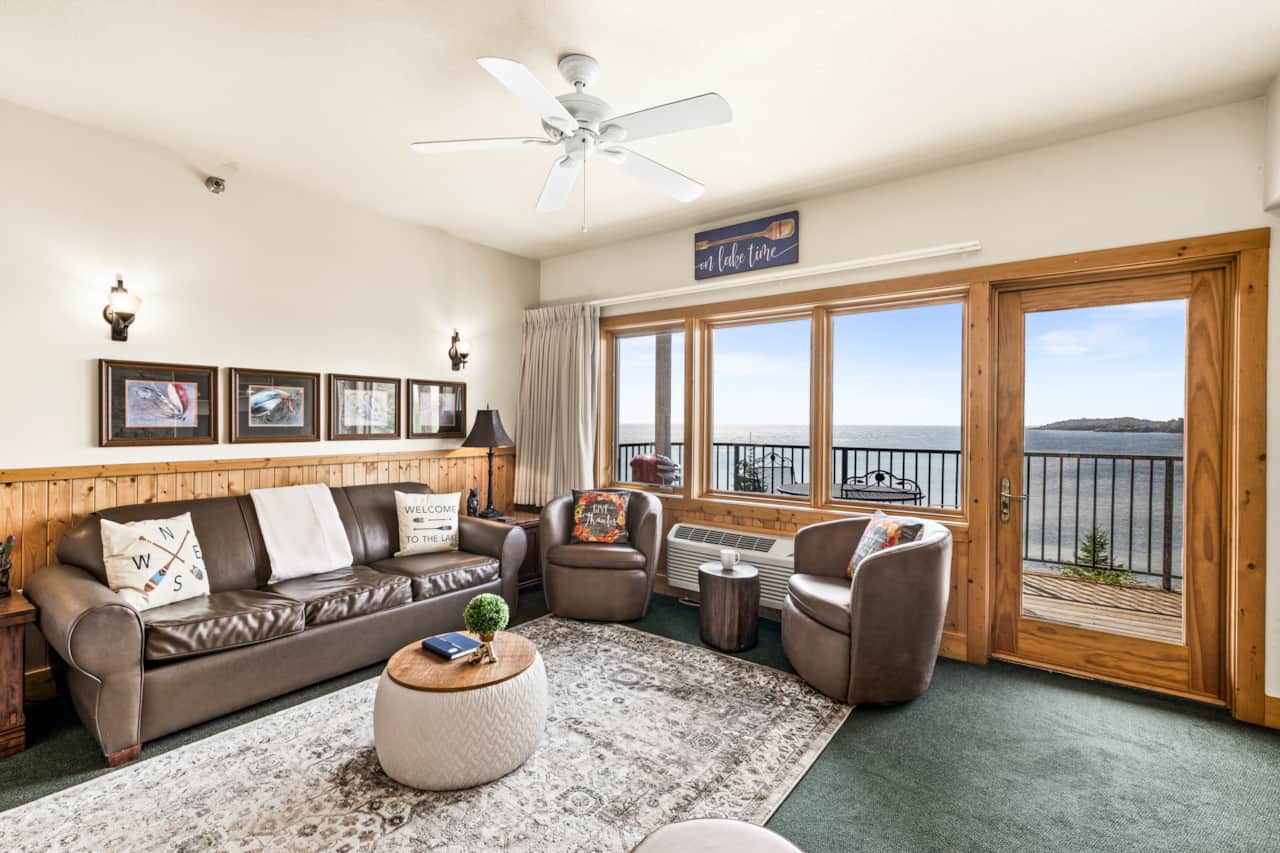 Cozy chairs, crackling fire, and the lake stretching out beyond the glass—pure serenity