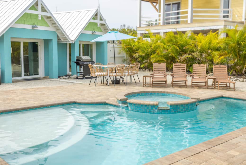 Private heated pool & spa by the AMI villa—palms, loungers, beach steps away.