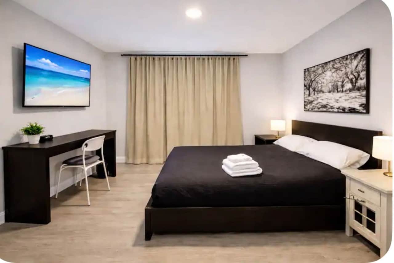 Comfortable bedroom with a queen-size bed, flat-screen TV, spacious closet, and modern décor.