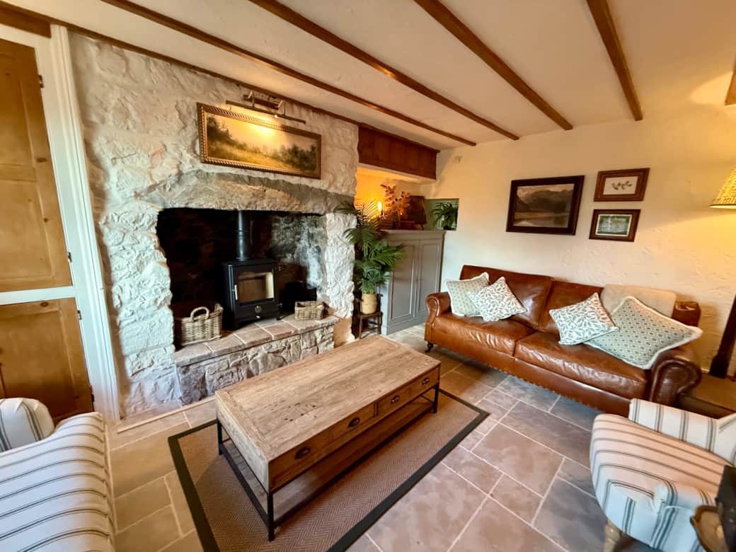 Cosy living room with log burner and comfortable sofas at Arwel Cottage, Llanbedrog