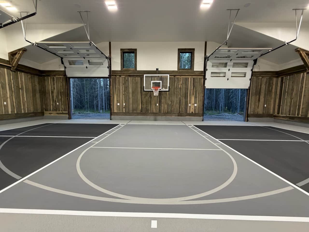 Private indoor basketball court surrounded by forest views