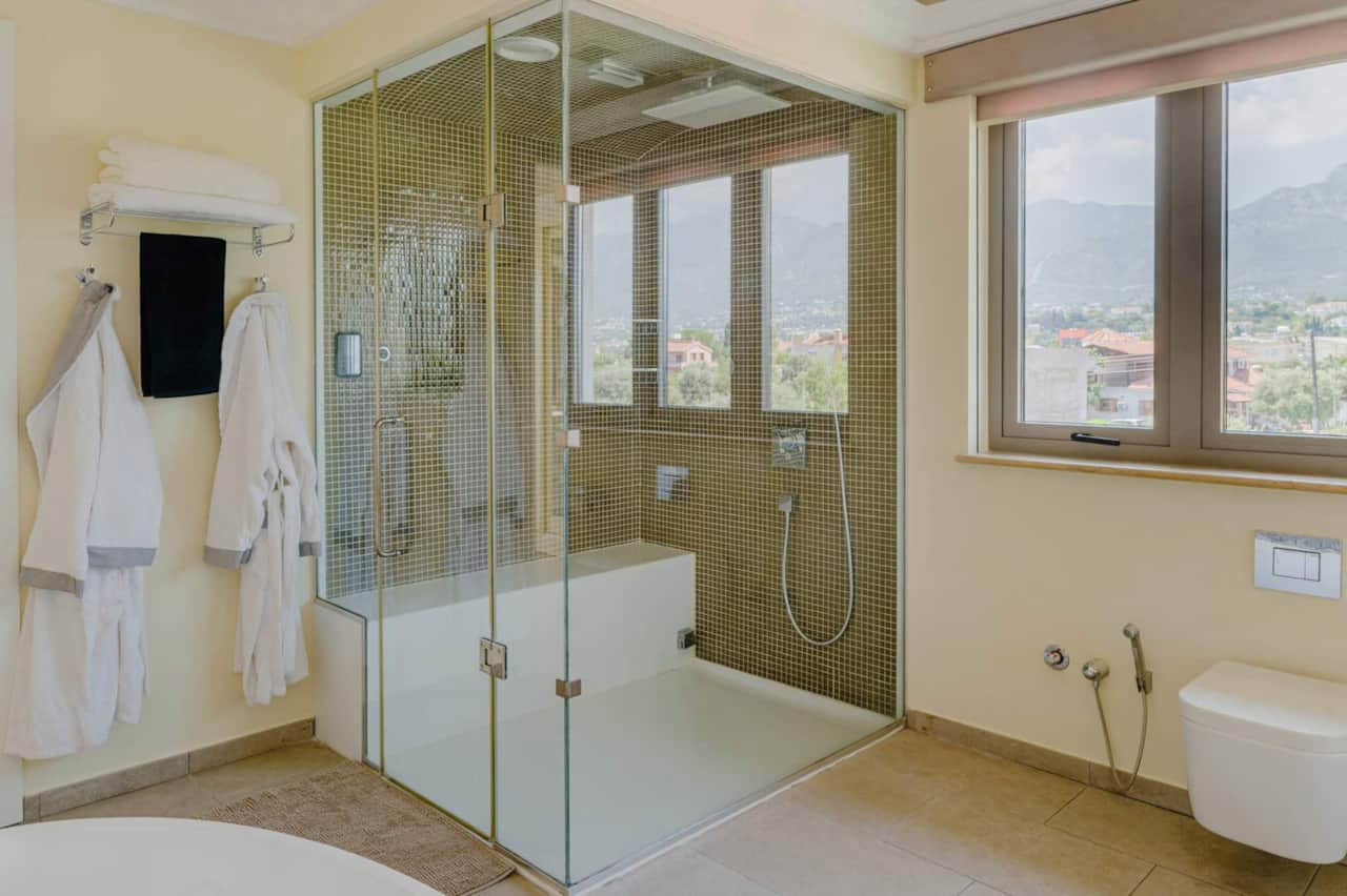 Ensuite bathroom with tub and steam shower, robes and toiletries.